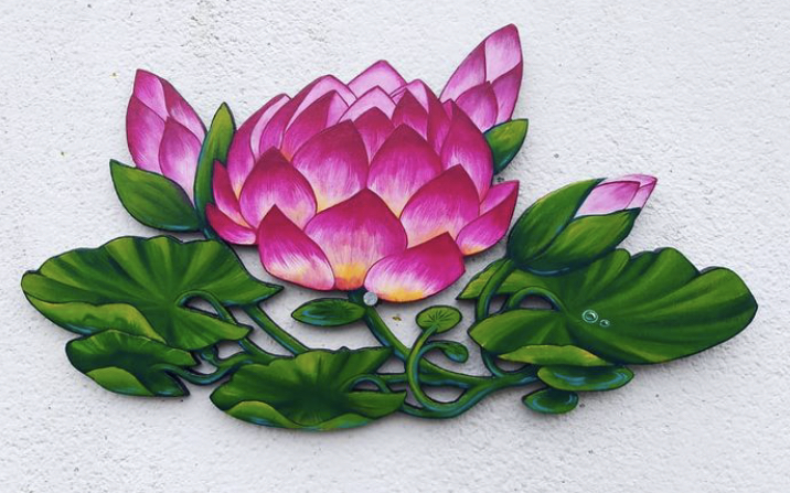 Hand painted wood cut out artwork by Lily Loy of a bright pink and green water lily. 