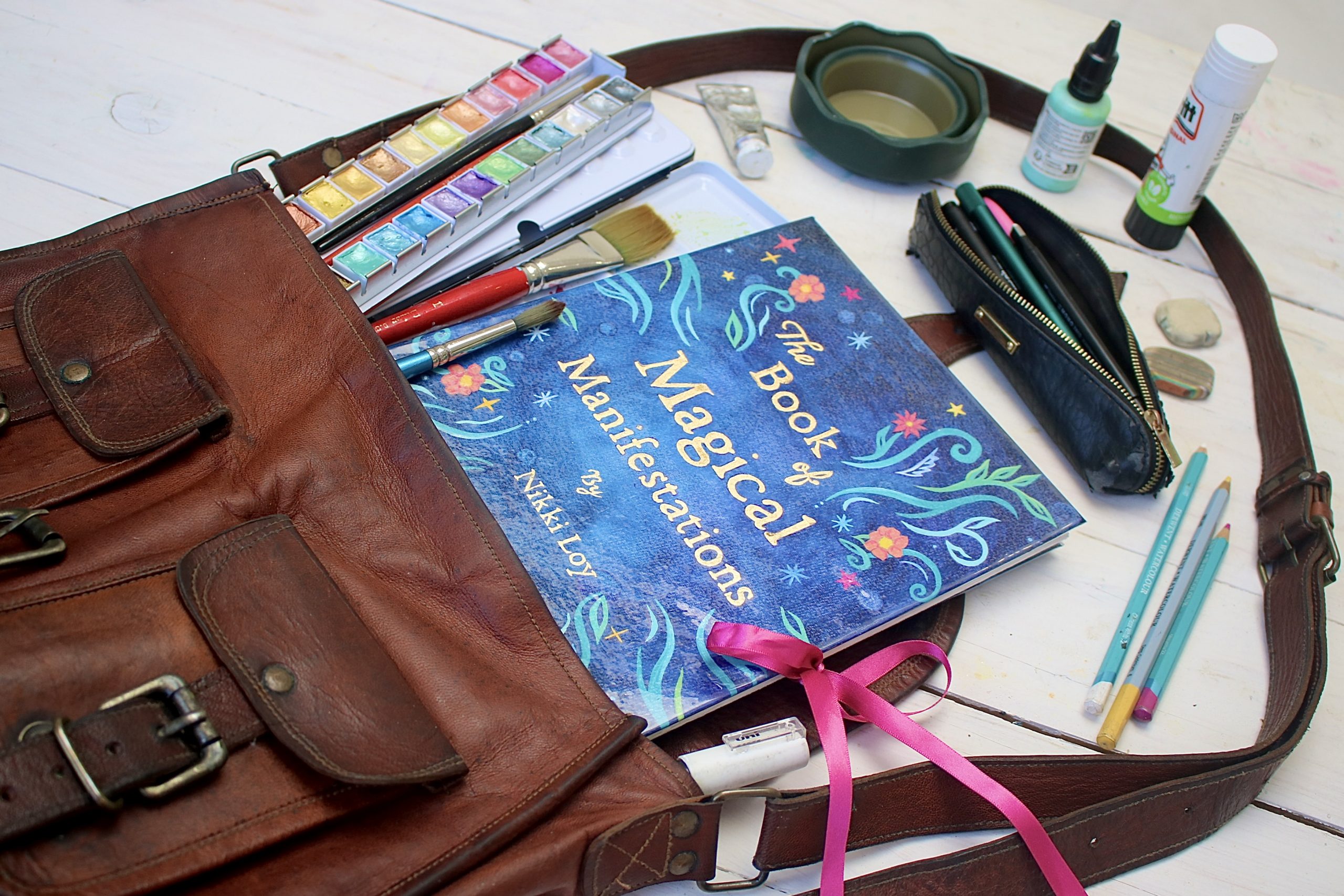 The Book of Magical Manifestations in an art satchel